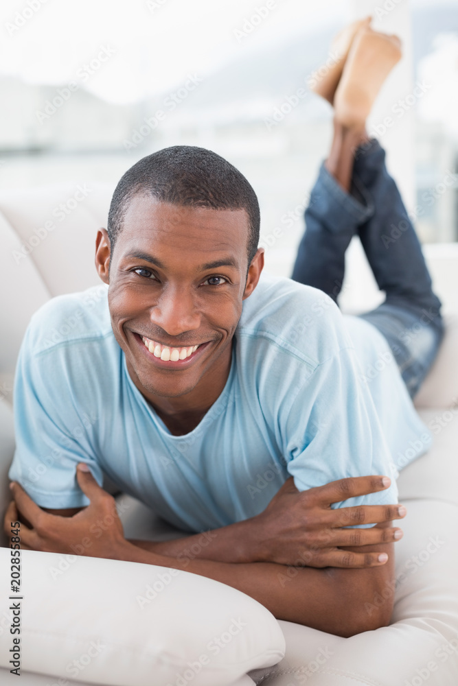 Relaxed smiling young Afro man lying on sofa Relaxed smiling young Afro man lying on sofa