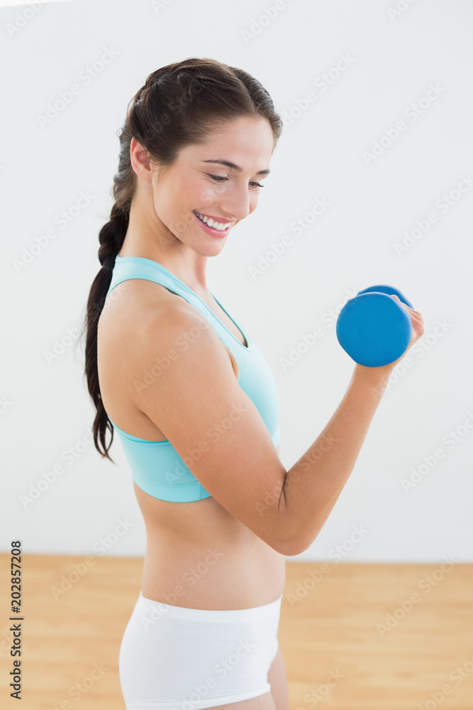 Smiling woman with dumbbell at fitness studio Smiling woman with dumbbell at fitness studio