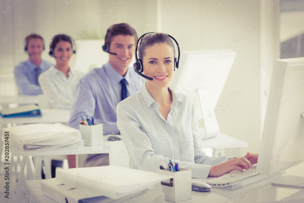 Business team working on computers and wearing headsets Business team working on computers and wearing headsets