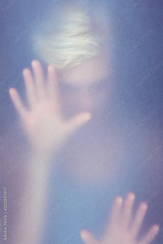 Blonde woman touching frosted glass