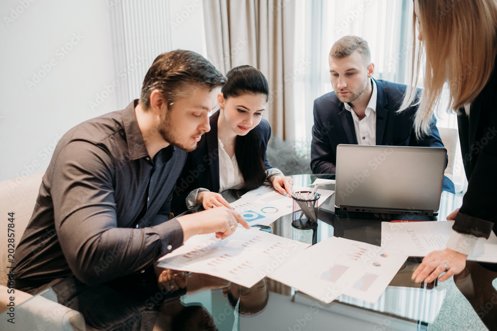 business team communication. results review. data analysis. men and women looking at documents discussing work moments business team communication. results review. data analysis. men and women looking at documents discussing work moments