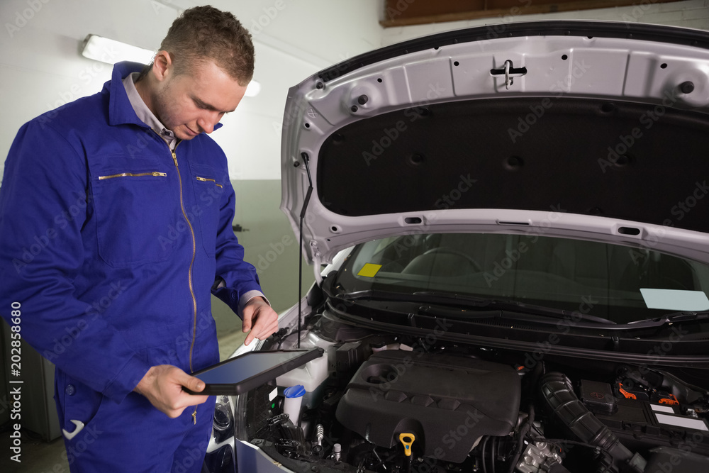 Mechanic looking at a tablet computer Mechanic looking at a tablet computer