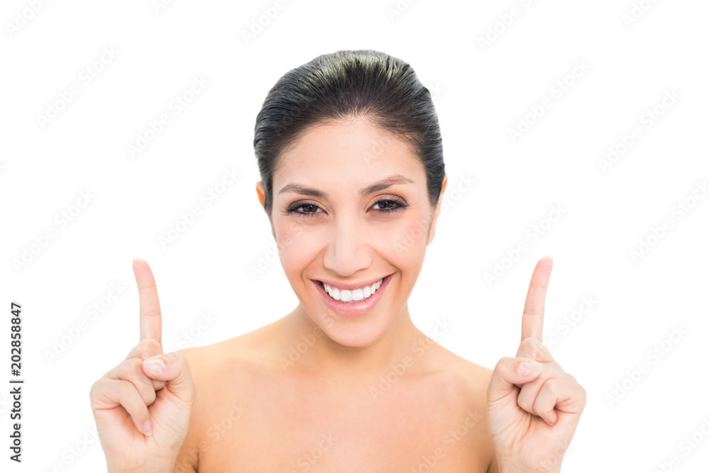 Smiling brunette pointing up with both hands Smiling brunette pointing up with both hands