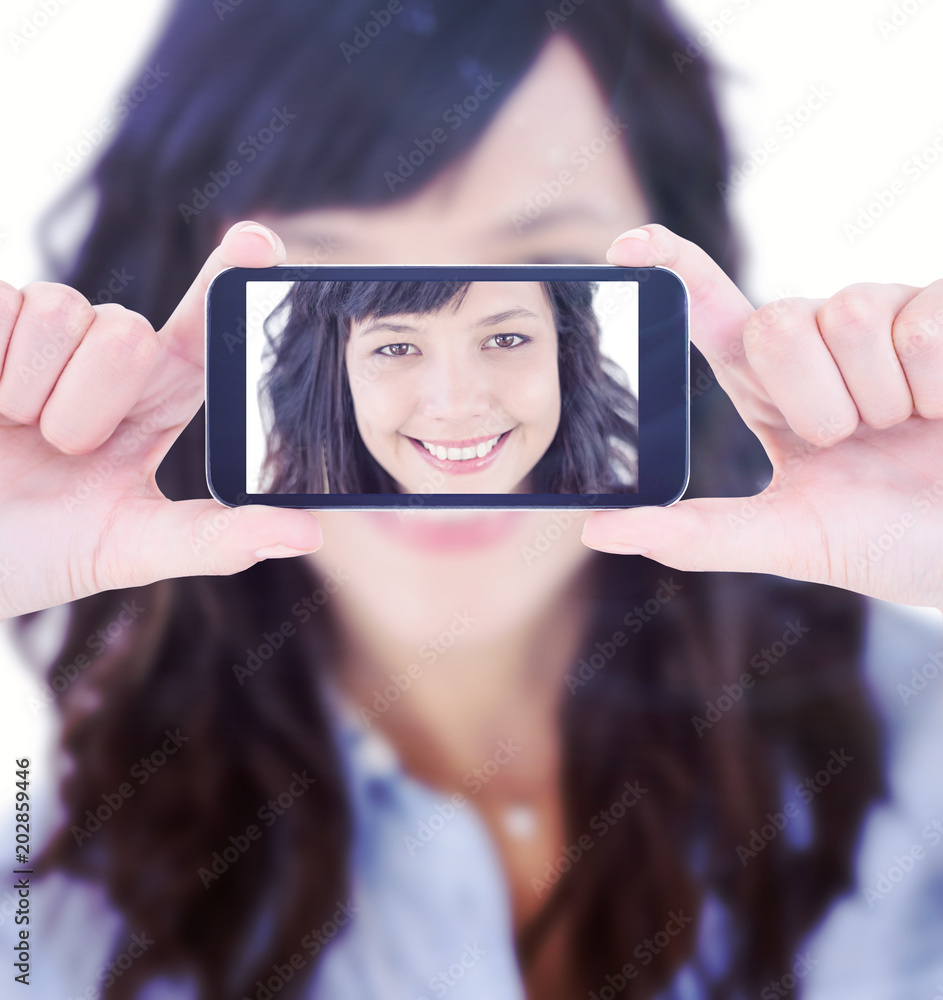 Hands holding smartphone against portrait of a smiling young woman