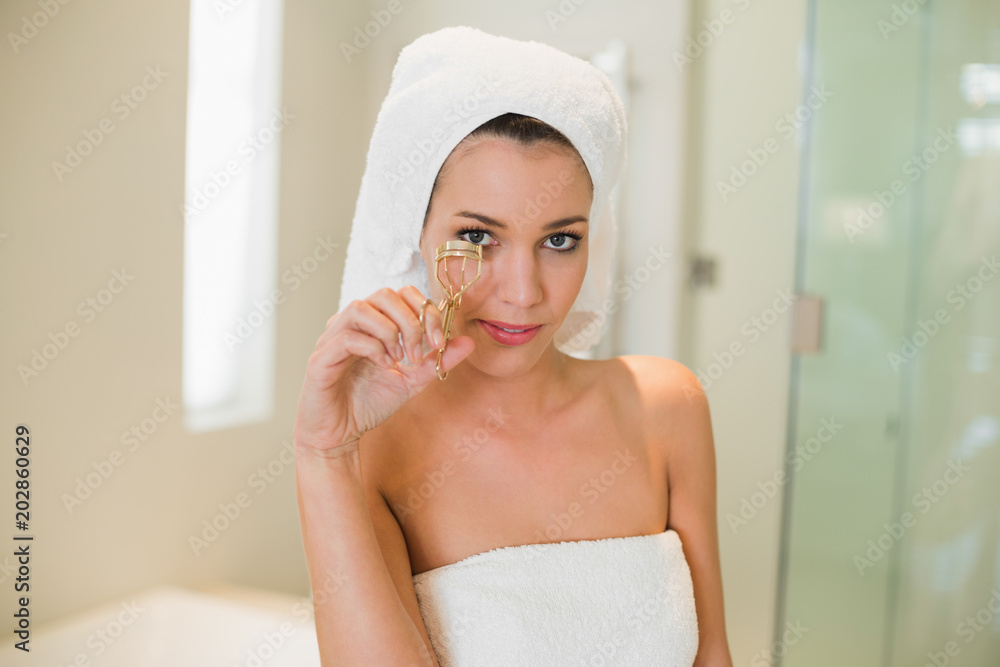 Calm natural brown haired woman using eyelash curler Calm natural brown haired woman using eyelash curler