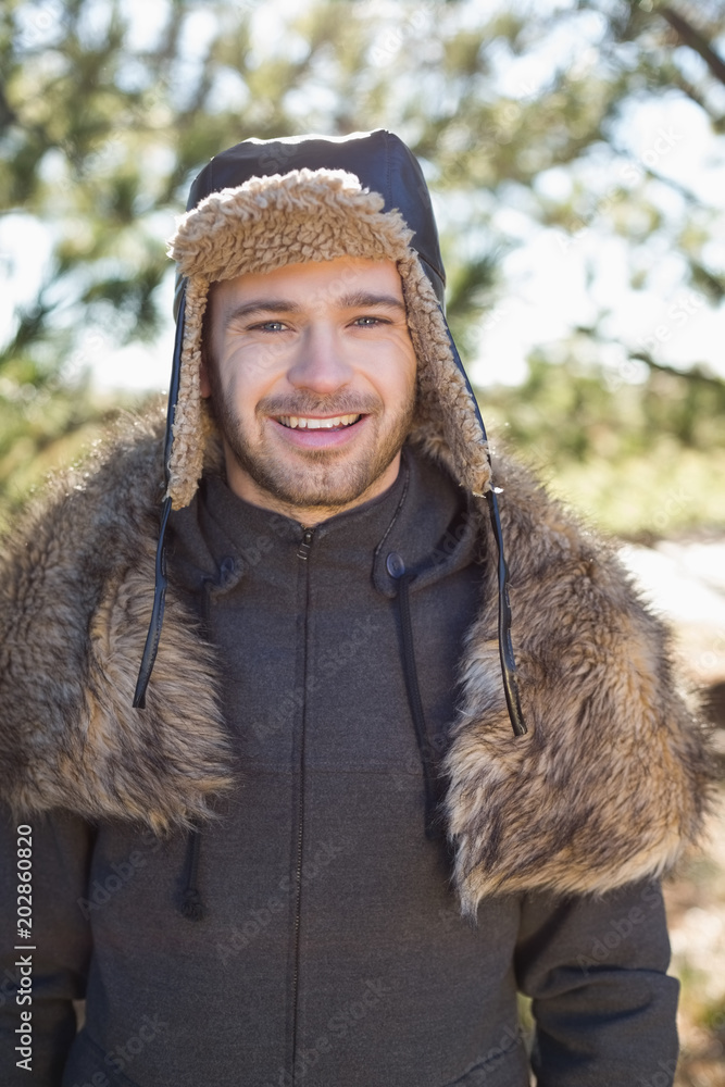 Smiling man in warm clothing standing in forest Smiling man in warm clothing standing in forest