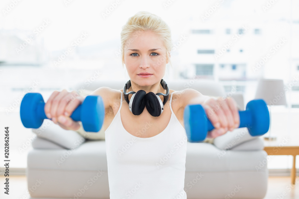 Fit woman with dumbbells at fitness studio
