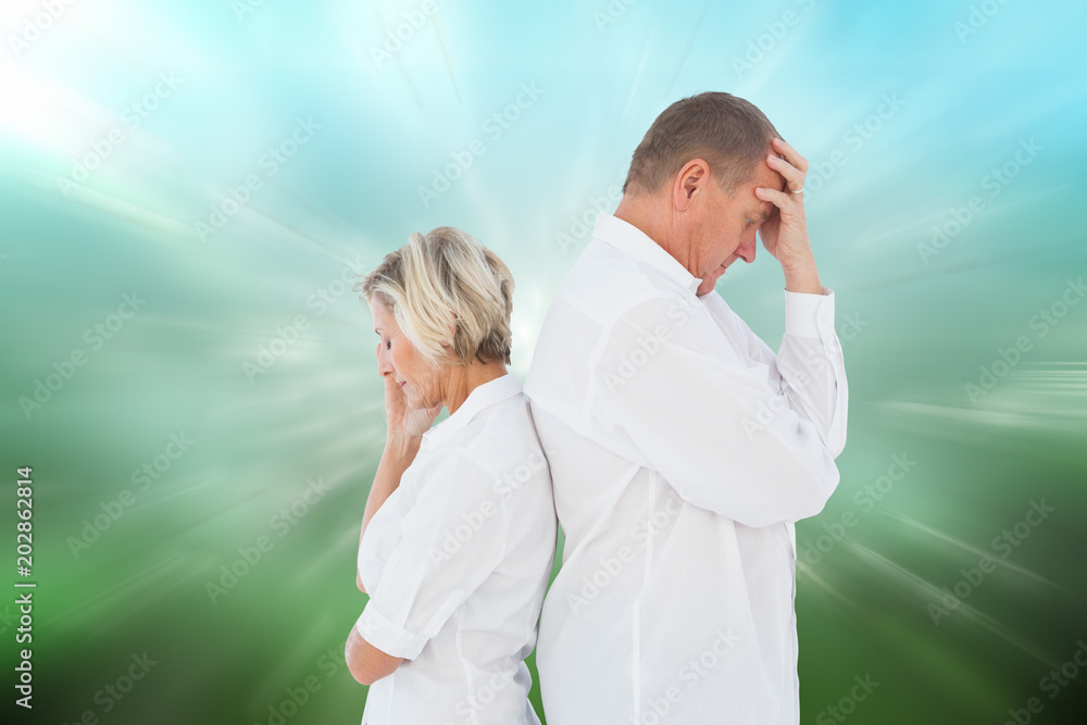 Upset couple not talking to each other after fight against digitally generated dandelion seeds on green background Upset couple not talking to each other after fight against digitally generated dandelion seeds on green background