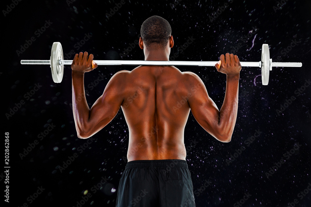 Rear view of a fit shirtless man lifting barbell against black background Rear view of a fit shirtless man lifting barbell against black background
