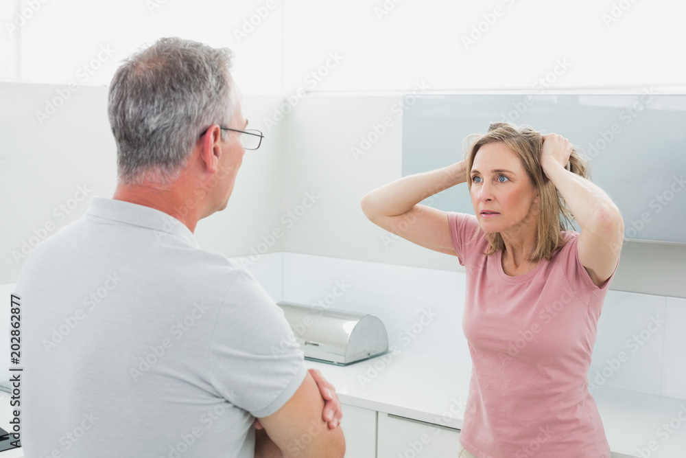 Unhappy couple having an argument in kitchen Unhappy couple having an argument in kitchen