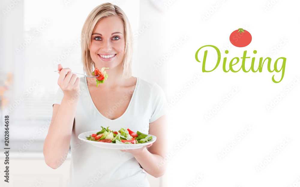The word dieting against close up of a cute woman eating salad The word dieting against close up of a cute woman eating salad