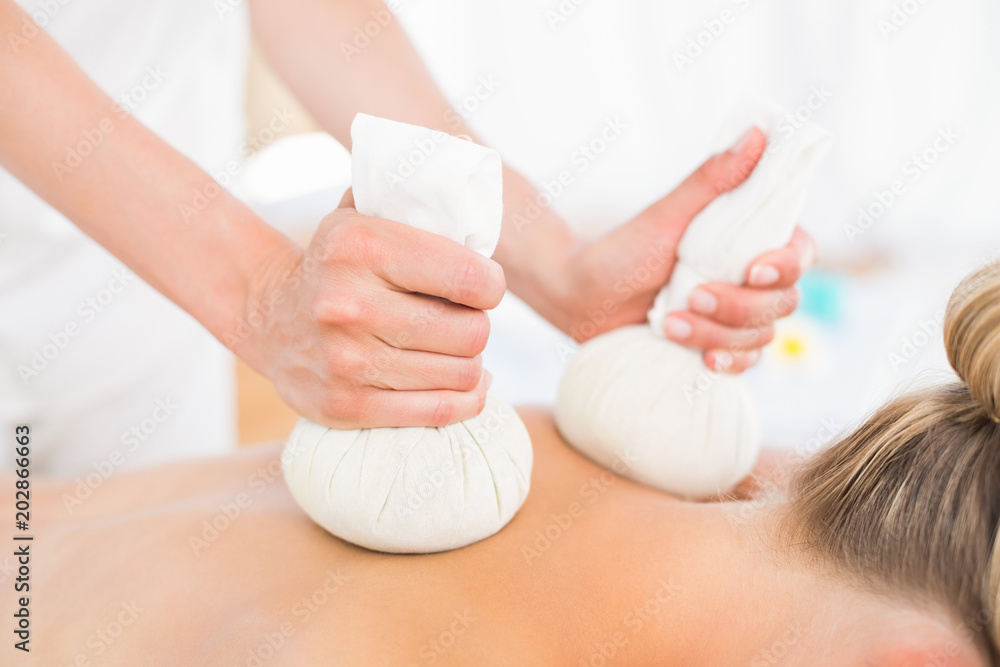 Fototapeta premium Beautiful blonde enjoying a herbal compress massage