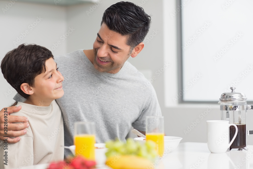 Young son with father having breakfast