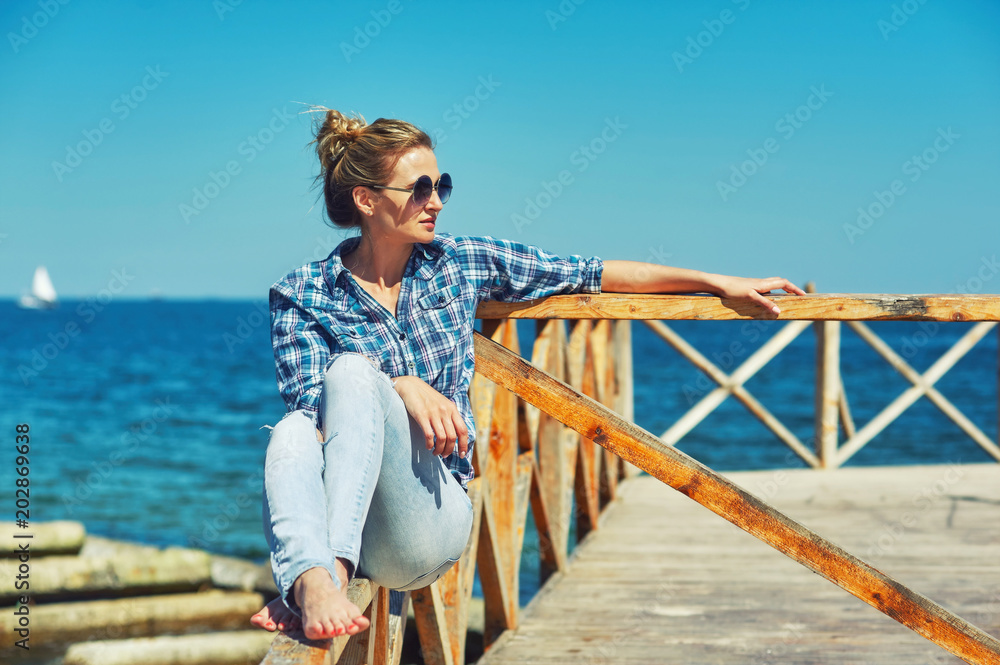 Portrait of a young woman on the beach. Girl resting on the seashore