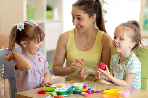 children and their mom make by hands playing with color dough
