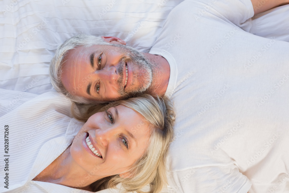 High angle portrait of a mature couple lying in bed High angle portrait of a mature couple lying in bed