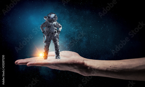 Spaceman in male hand. Mixed media