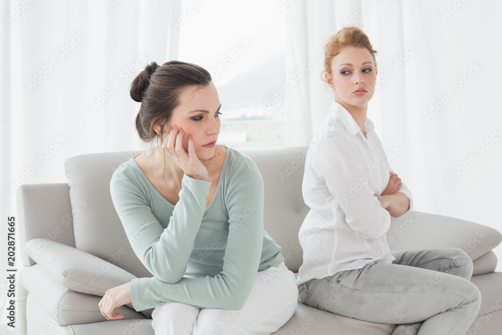 Unhappy friends not talking after argument on the couch Unhappy friends not talking after argument on the couch