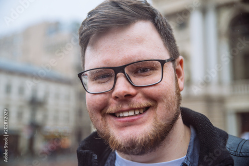 portrait of young adult man with eyeglasses in drops. man with wet hair