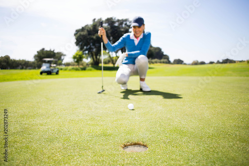 Female golfer putting her ball 