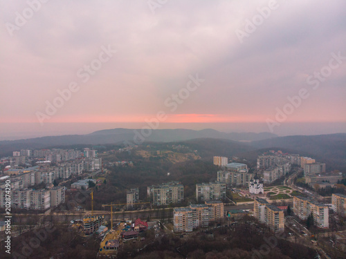 beautiful cityscape with sunrise. red sun rise above the mountains © phpetrunina14