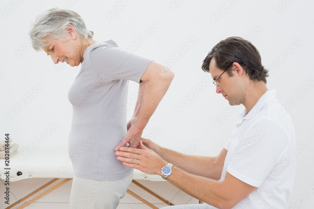 Obraz premium Physiotherapist examining senior womans back