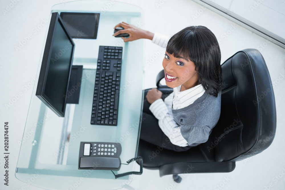 Overhead of smiling pretty businesswoman at work