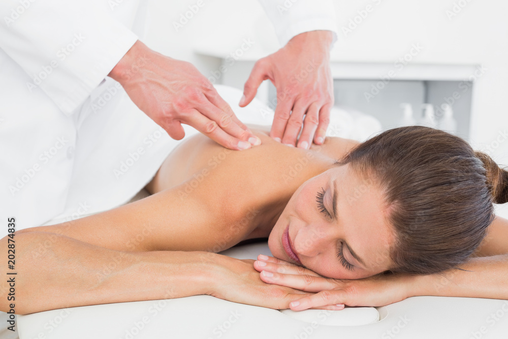 Male physiotherapist massaging womans back Male physiotherapist massaging womans back