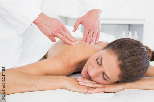 Male physiotherapist massaging womans back