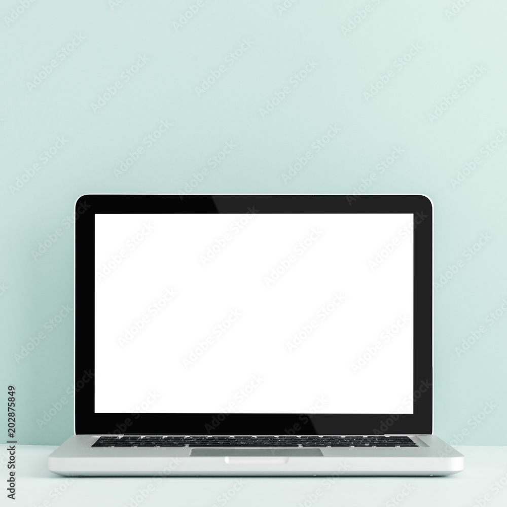 Table with macbook laptop on a bright green background. Mock up. Table with macbook laptop on a bright green background. Mock up.
