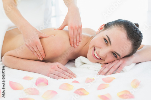 Woman enjoying shoulder massage at beauty spa