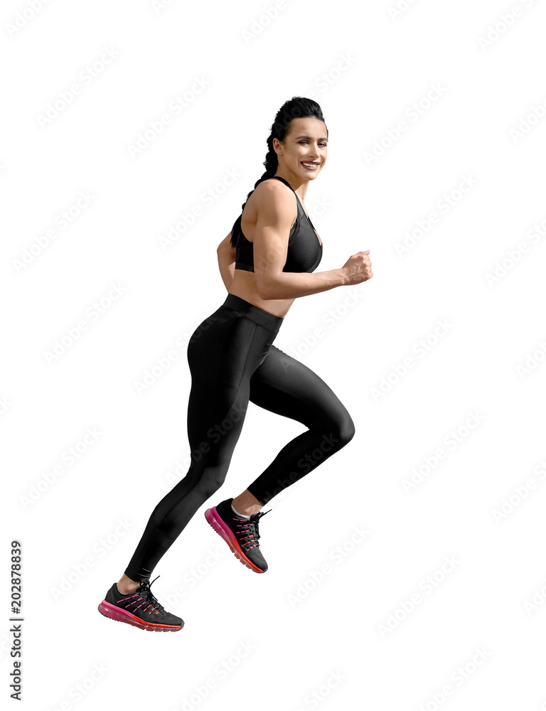 Obraz premium sideview of running athletic female. Smiling woman with fit, curvy body doing sport exercises. Model having slim, stunning figure, wearing sport trousers and top, also sneackers for professional run.