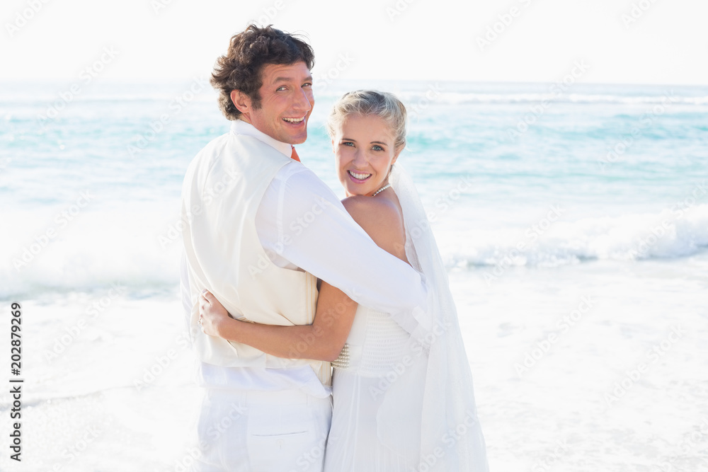 Newlyweds standing by the sea smiling at camera Newlyweds standing by the sea smiling at camera