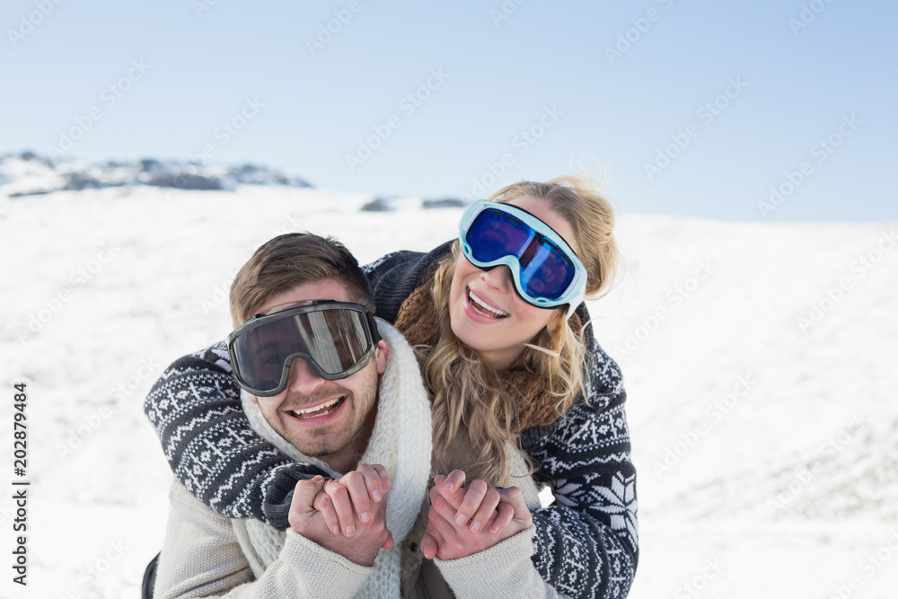 Cheerful couple in ski goggles on snow Cheerful couple in ski goggles on snow