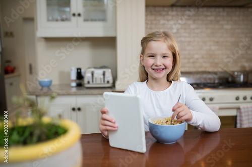 Young girl having breakfast in the kitchen at home
