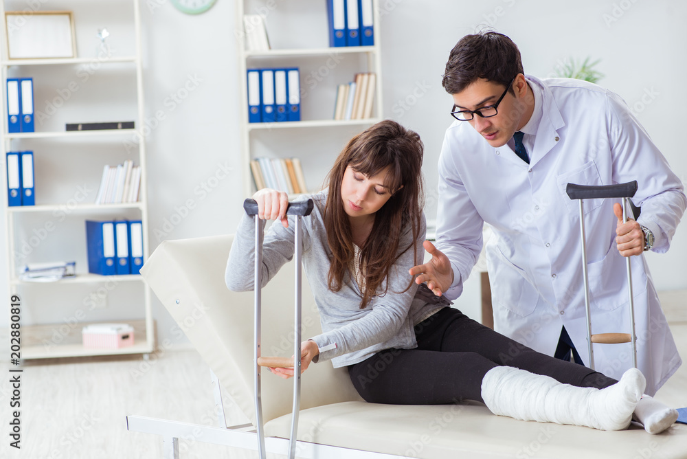 Doctor examining patient with broken leg Doctor examining patient with broken leg