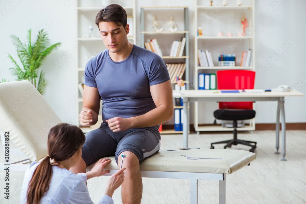 Doctor checking patients joint flexibility with gonimeter Doctor checking patients joint flexibility with gonimeter
