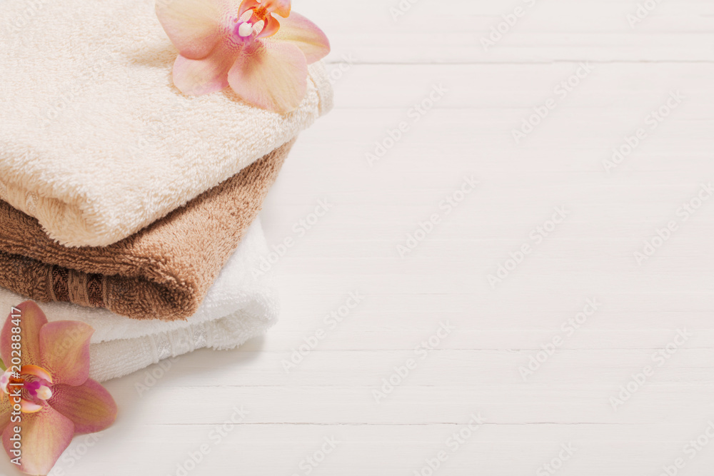 orchid with towels on white wooden background orchid with towels on white wooden background