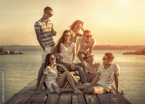 Happiness friends on pier under sunset light. © Andrii IURLOV