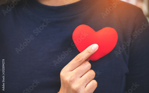 Closeup image of hands holding a red heart sign