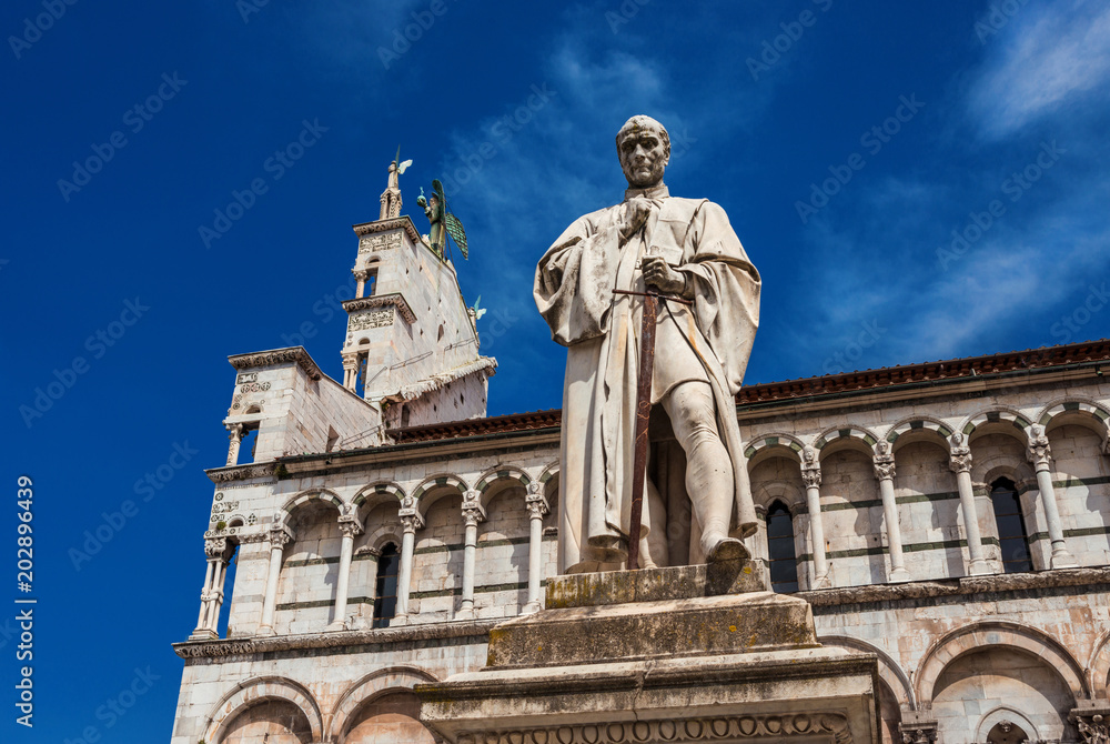 Francesco Burlamacchi monument erected in 1863 in the historic center of Lucca, with ancient Saint Michael in Foro Church in the backgorund