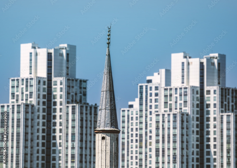 A minaret with skyscrapers background in Istanbul A minaret with skyscrapers background in Istanbul