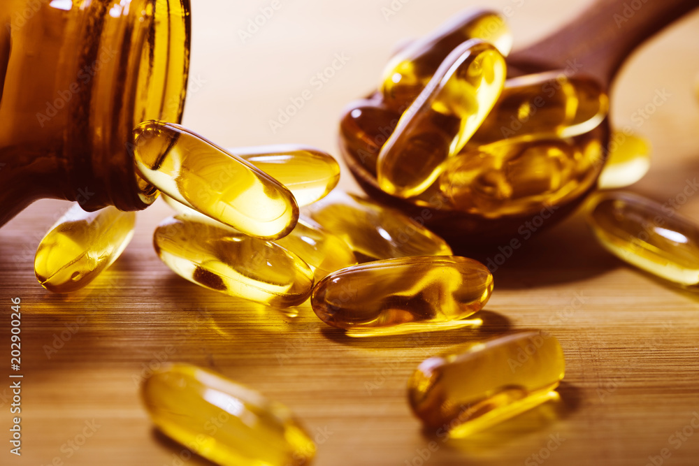 Φωτογραφία Close up the vitamin D and Omega 3 fish oil capsules supplement on wooden plate
