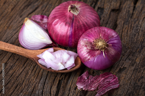 Close up of the sliced red onion and whole bulb onion on a wooden background