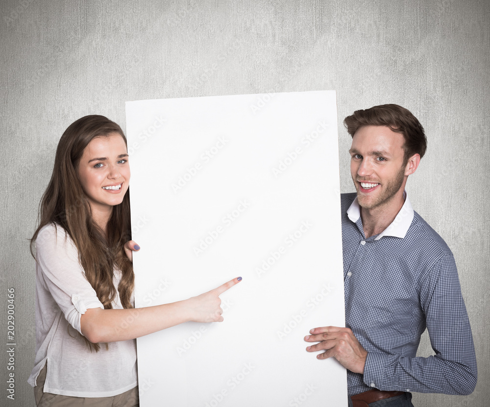 Happy young couple with blank board against weathered surface Happy young couple with blank board against weathered surface