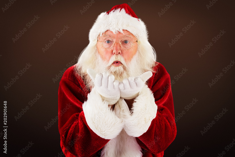 Naklejka premium Santa Claus blows something away against dark brown background