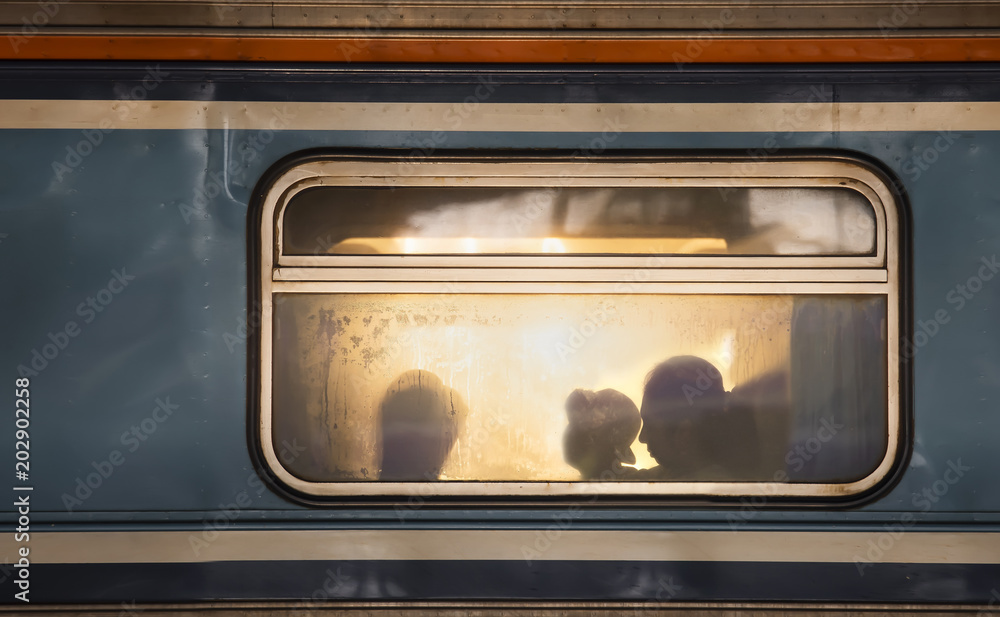 Obraz premium Sylwetki pasażerów w starym wagonie kolejowym