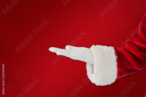Santa claus presenting with hand against red background