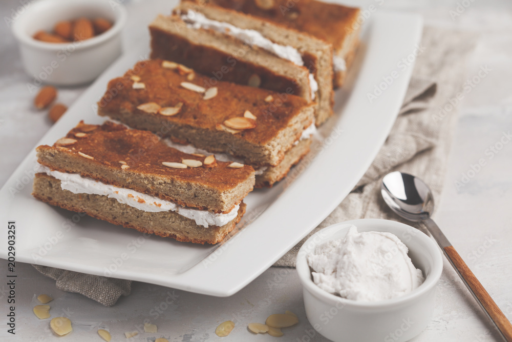 Vegan cake with coconut cream and almonds. Light background, healthy vegan dessert. Healthy vegan food concept. Vegan cake with coconut cream and almonds. Light background, healthy vegan dessert. Healthy vegan food concept.