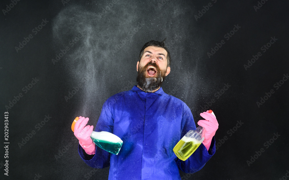 Bearded man with cleaning equipment. Cleaning concept. Portrait of angry bearded man with cleaning spray. Cleaning service and work concept. Man shows cleaning tools.